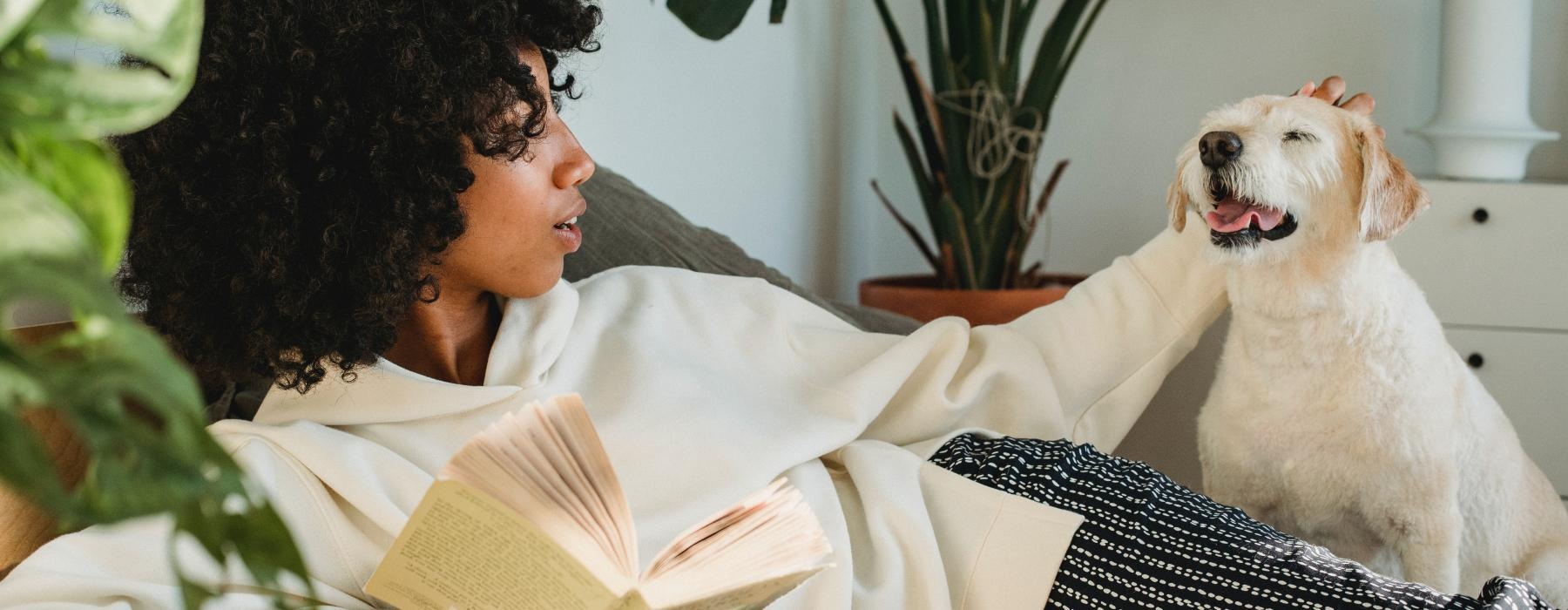 a person reading a book with a dog